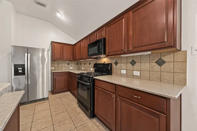 a kitchen with stainless steel appliances granite countertop a refrigerator stove and sink