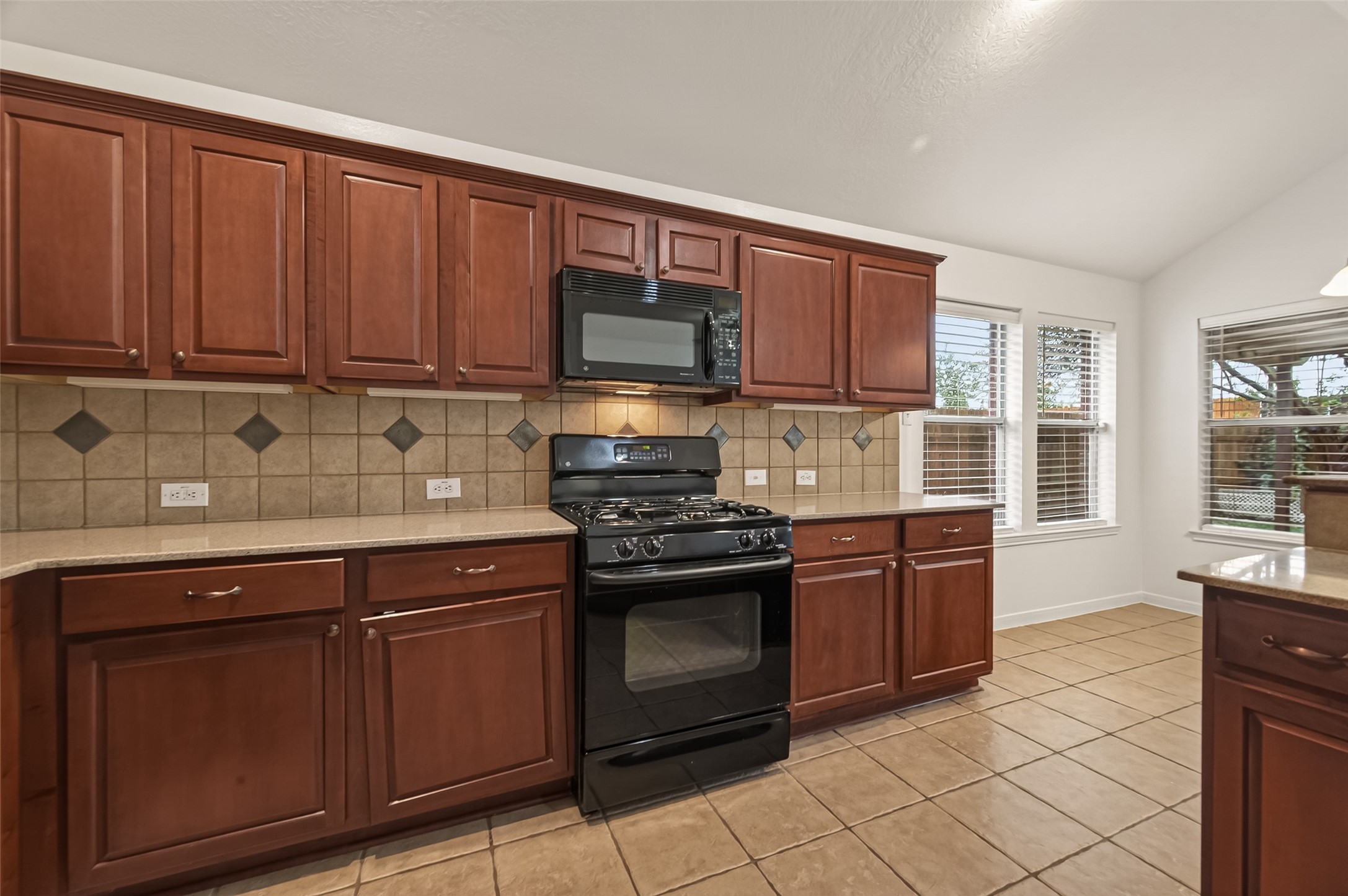 2704 Hewn Rock Way Pearland, TX 77584 - Photo 16 of 40 a kitchen with granite countertop wooden cabinets and a stove top oven