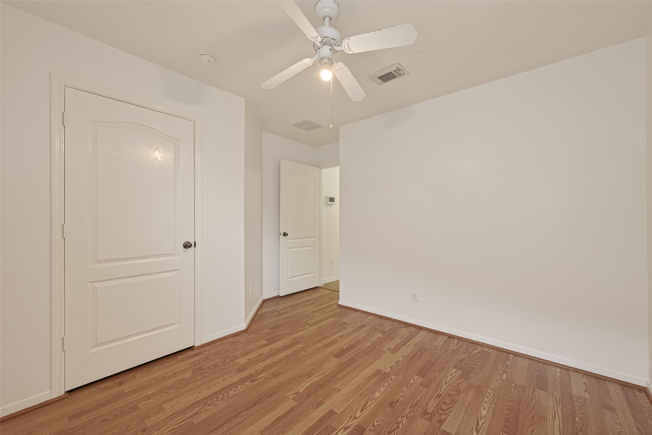 2704 Hewn Rock Way Pearland, TX 77584 - Photo 18 of 40 an empty room with wooden floor and fan