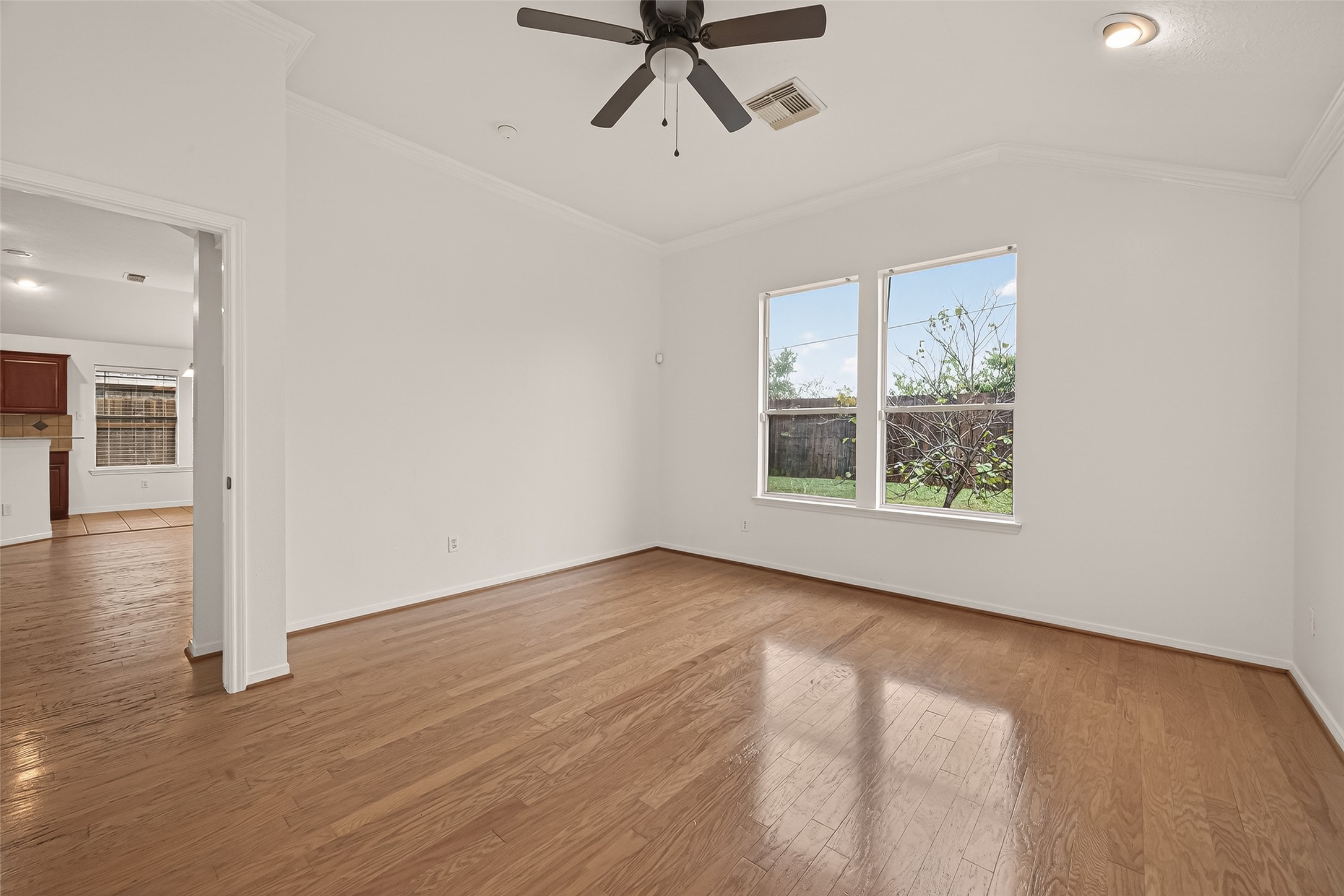2704 Hewn Rock Way Pearland, TX 77584 - Photo 32 of 40 an empty room with wooden floor a ceiling fan and windows