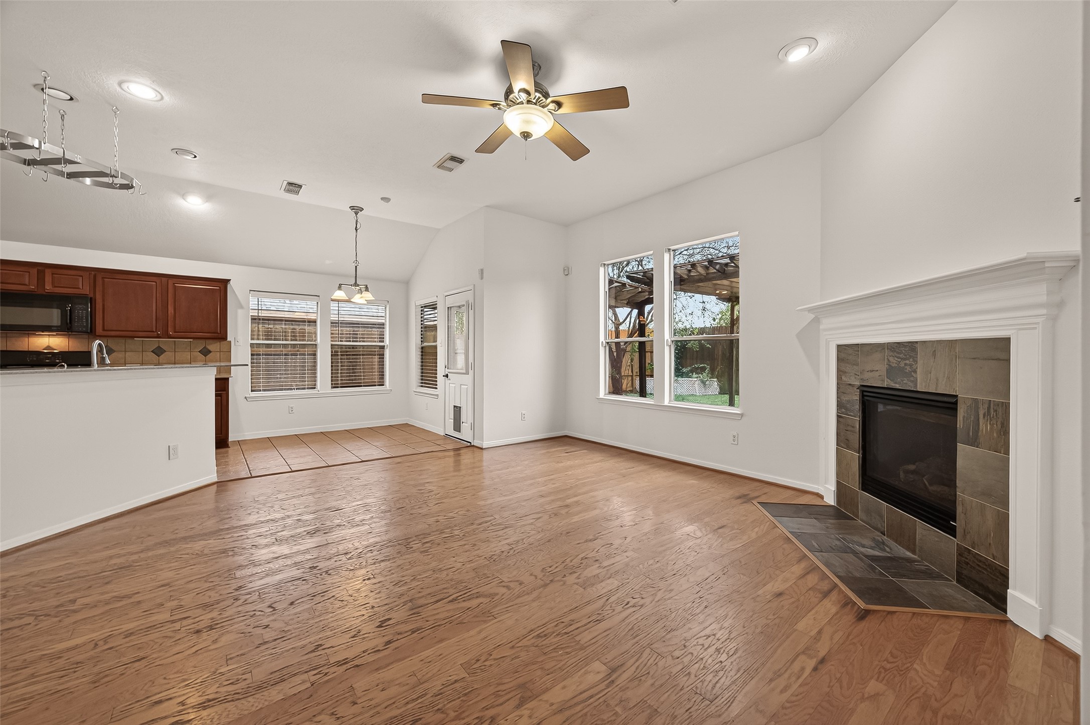 2704 Hewn Rock Way Pearland, TX 77584 - Photo 8 of 40 an empty room with windows fireplace and a kitchen view