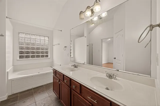 a spacious bathroom with a tub sink shower and mirror