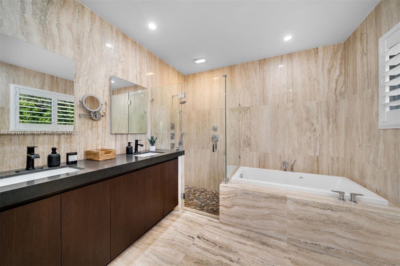 12050 Moss Ranch Road Pinecrest, FL 33156 - Photo 15 of 33 a bathroom with a double vanity sink a large mirror and a bathtub