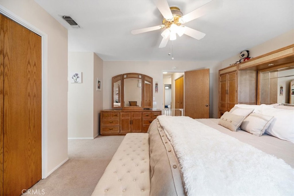 834 Nicklaus Street Paso Robles, CA 93446 - Photo 15 of 37 a bedroom with a large bed and a chandelier