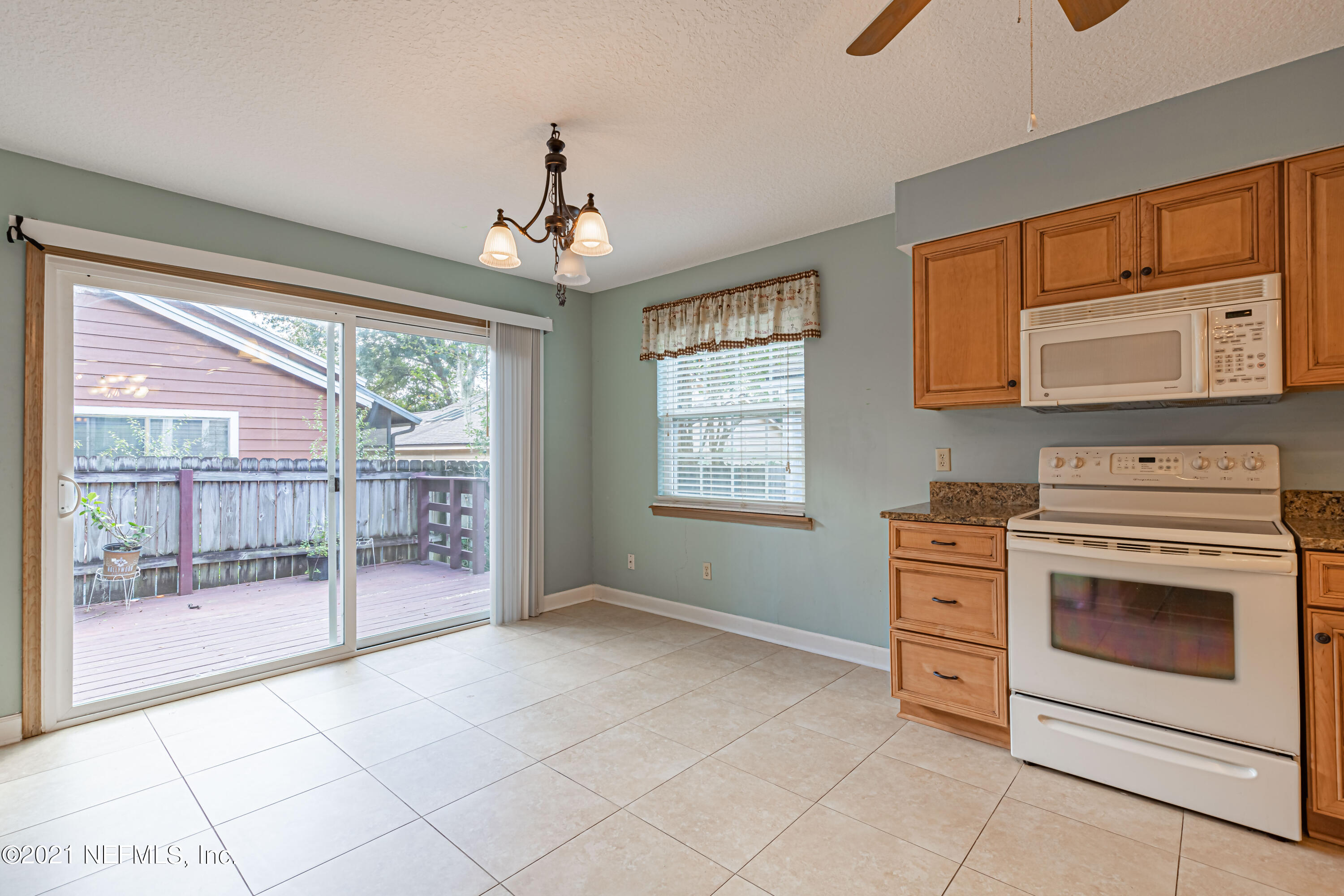 5416 Spring Brook Road Jacksonville, FL 32277 - Photo 14 of 27 a kitchen with granite countertop a stove top oven cabinetry a sink and a chandelier