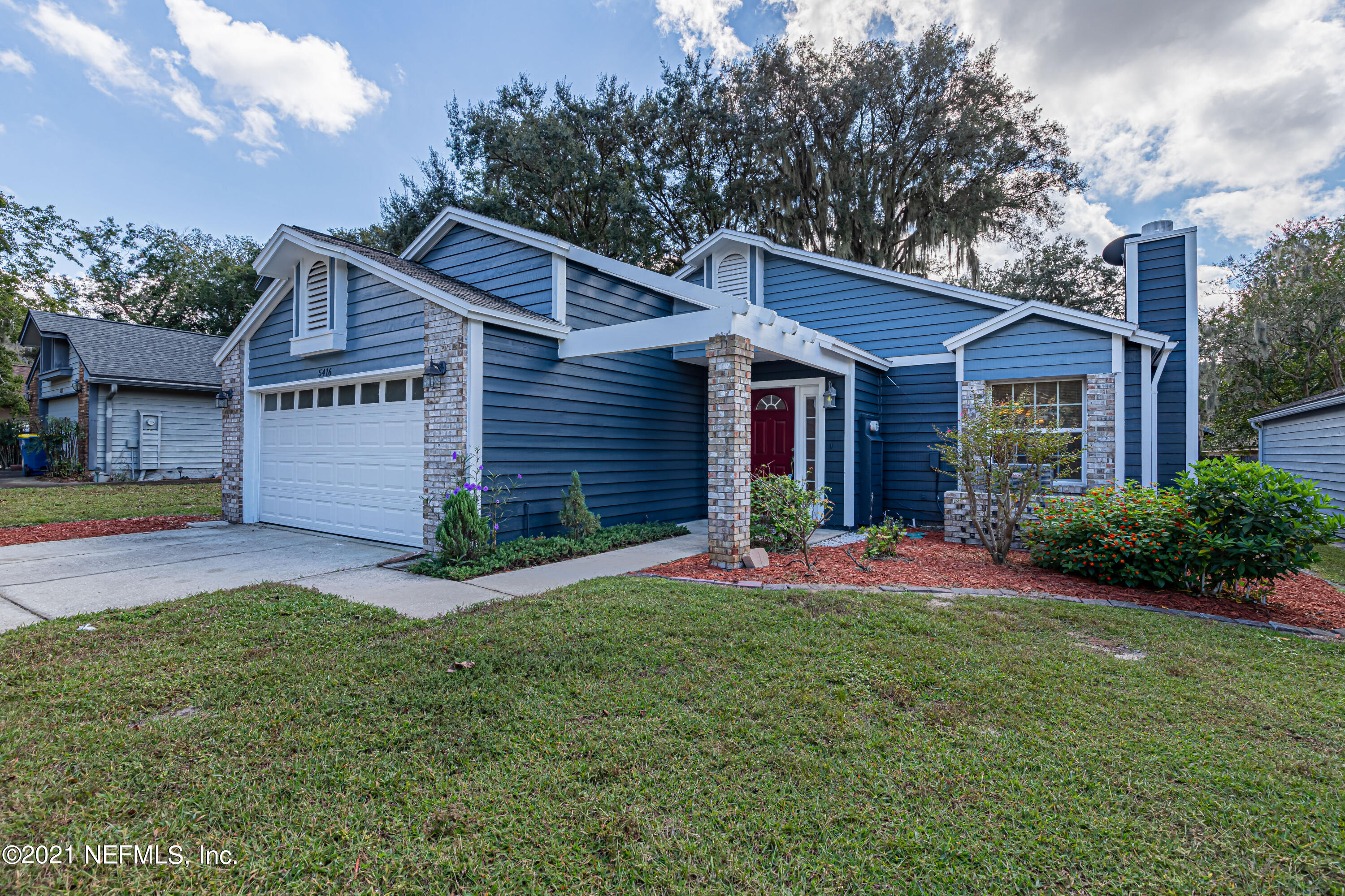 5416 Spring Brook Road Jacksonville, FL 32277 - Photo 2 of 27 a front view of a house with a yard and garage