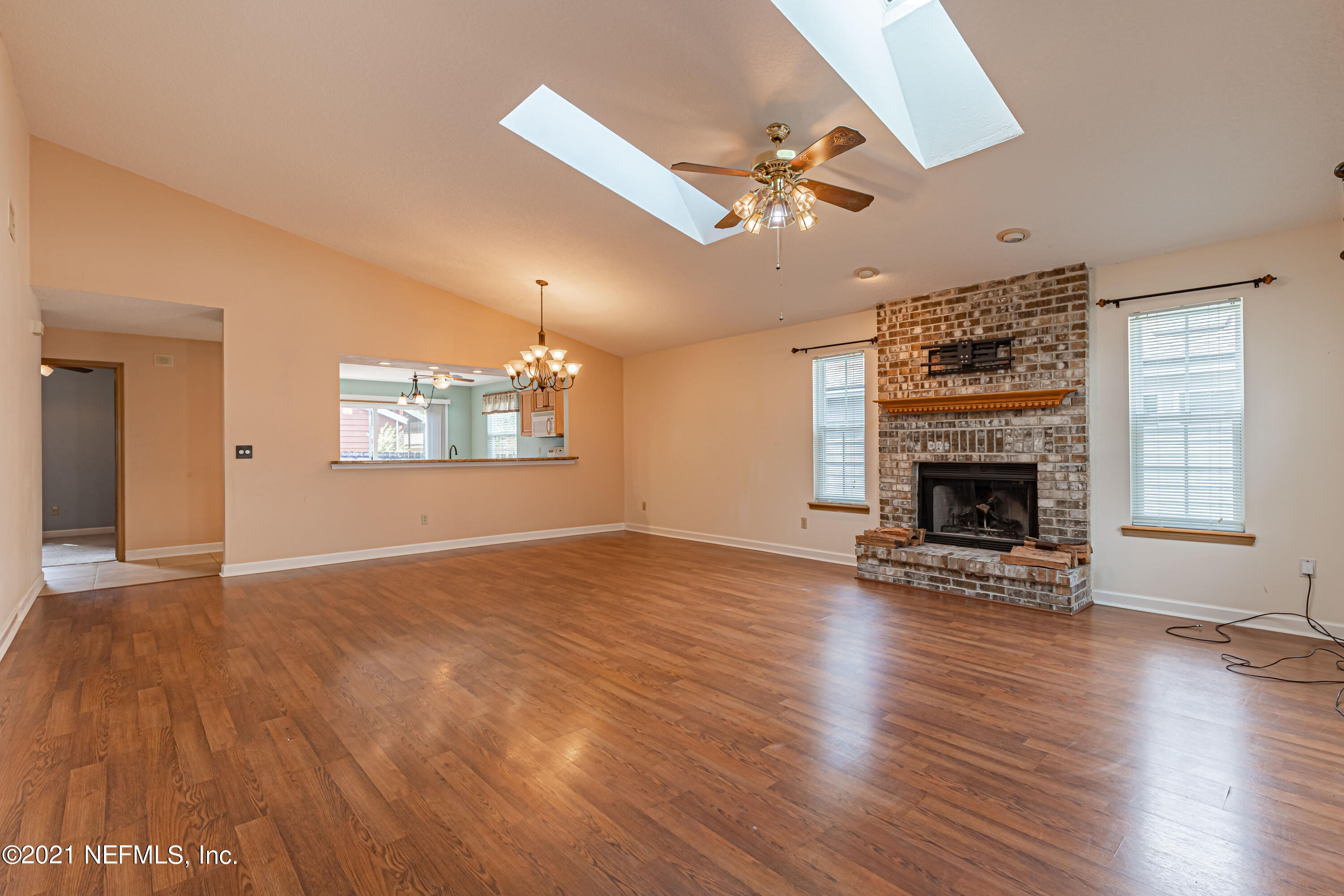 5416 Spring Brook Road Jacksonville, FL 32277 - Photo 6 of 27 wooden floor fireplace and windows in an empty room