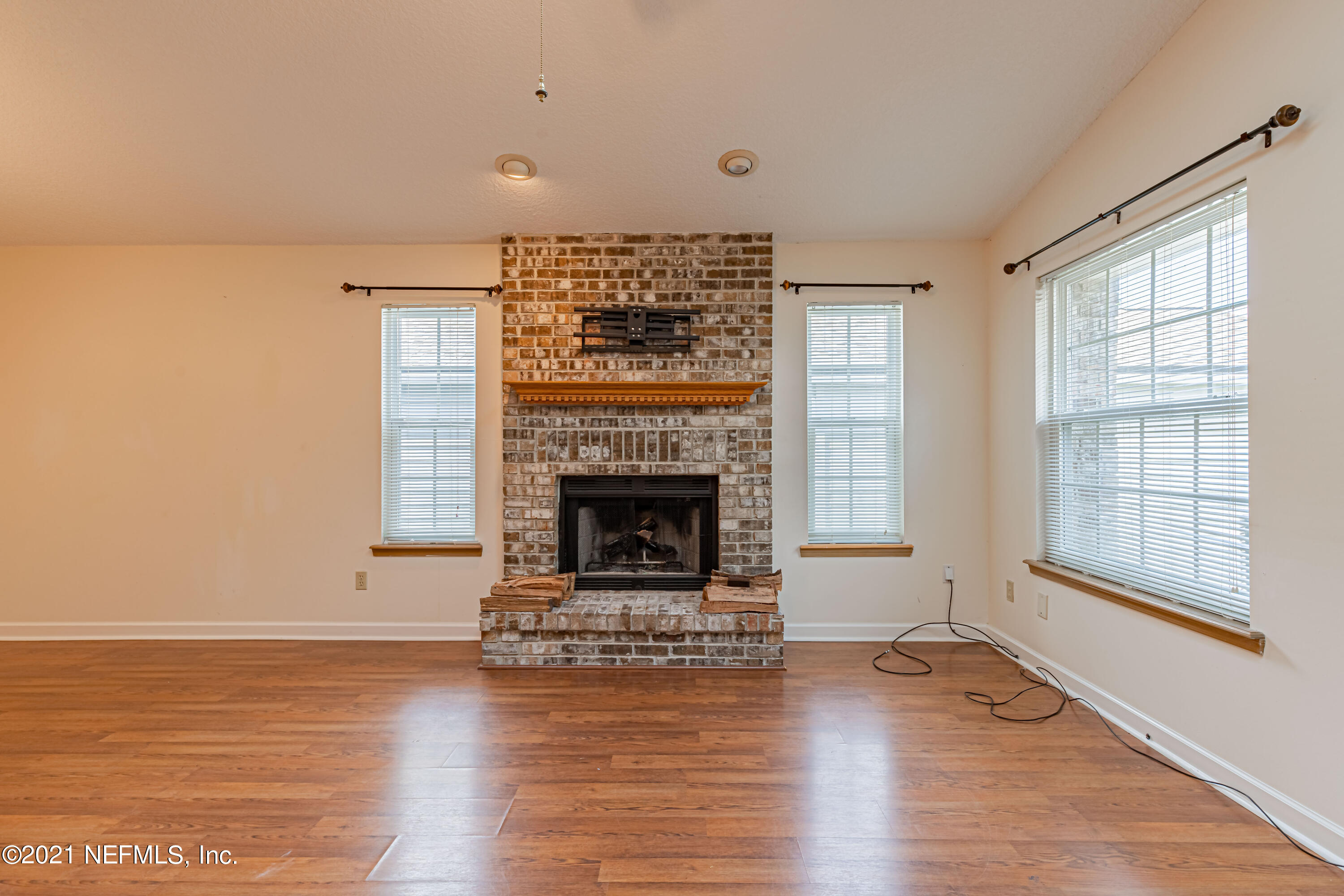 5416 Spring Brook Road Jacksonville, FL 32277 - Photo 10 of 27 a living room with a fireplace and wooden floor