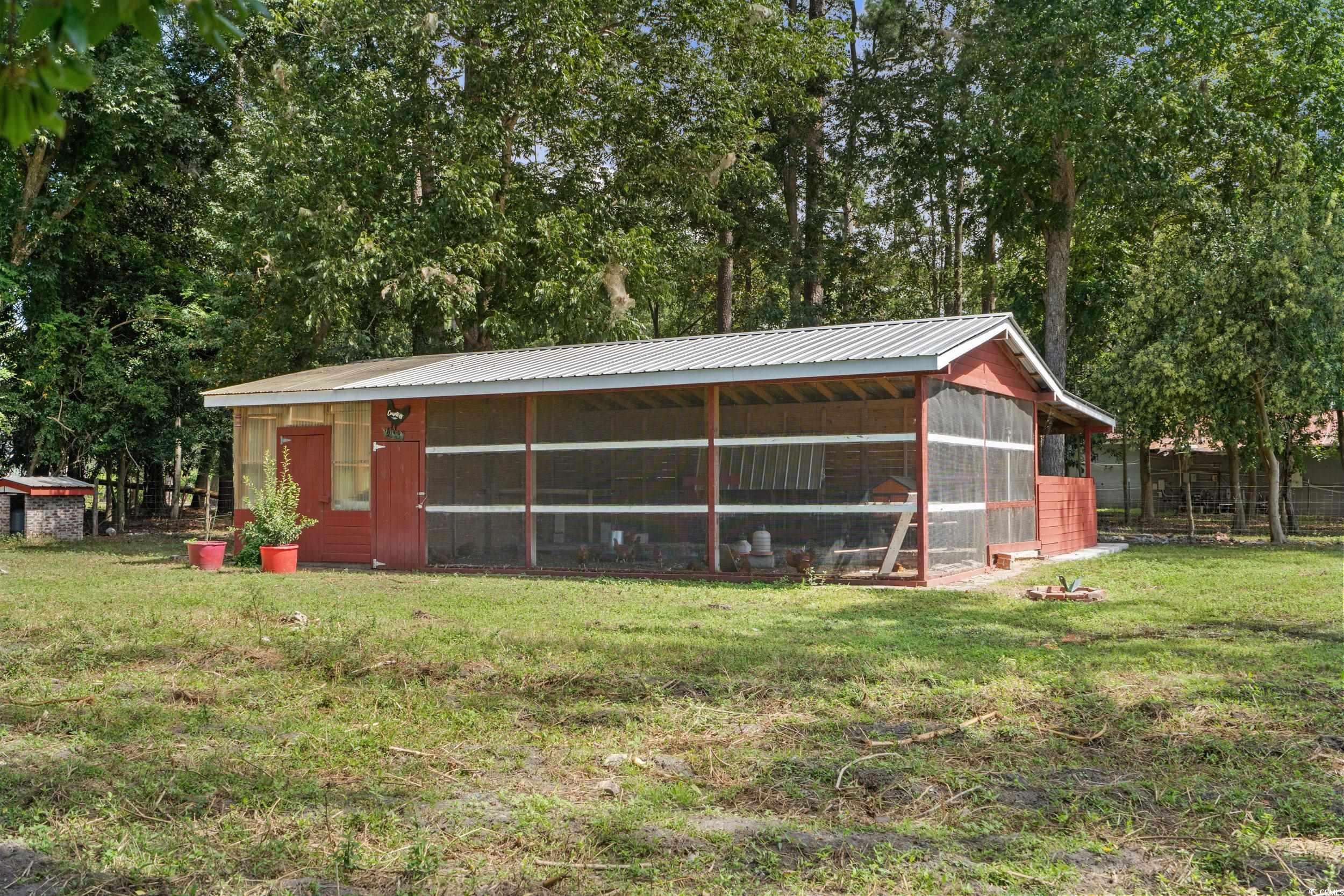 2323 Main Street Loris, SC 29569 - Photo 11 of 40 View of poultry coop with a sunroom and view of wooded area