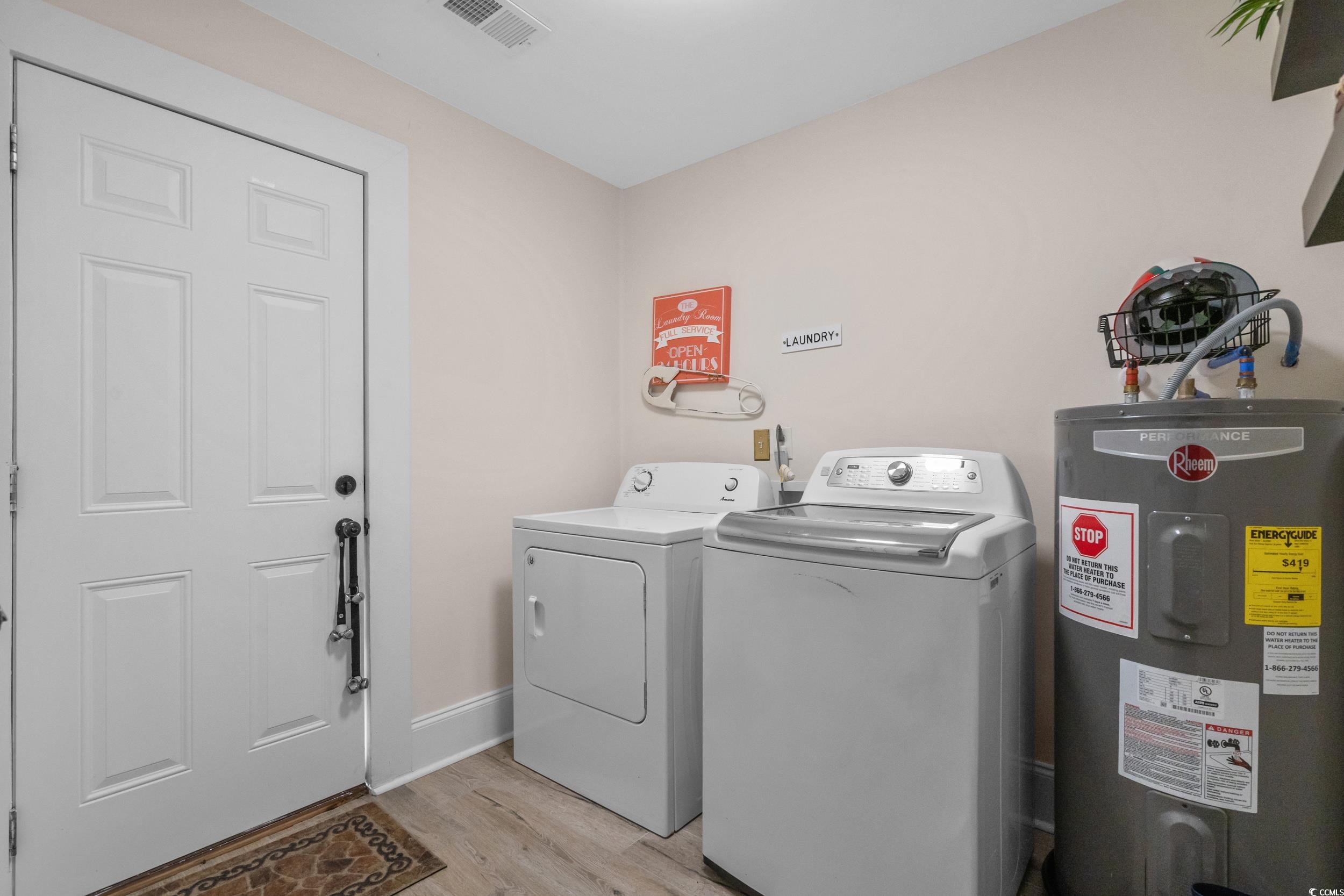 2323 Main Street Loris, SC 29569 - Photo 37 of 40 Laundry area with water heater, light wood-style floors, and washer and dryer