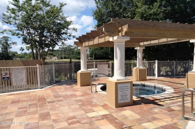 a view of a patio with a dining table and chairs with wooden fence
