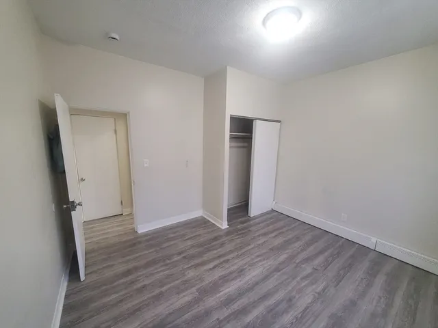 an empty room with wooden floor and entrance