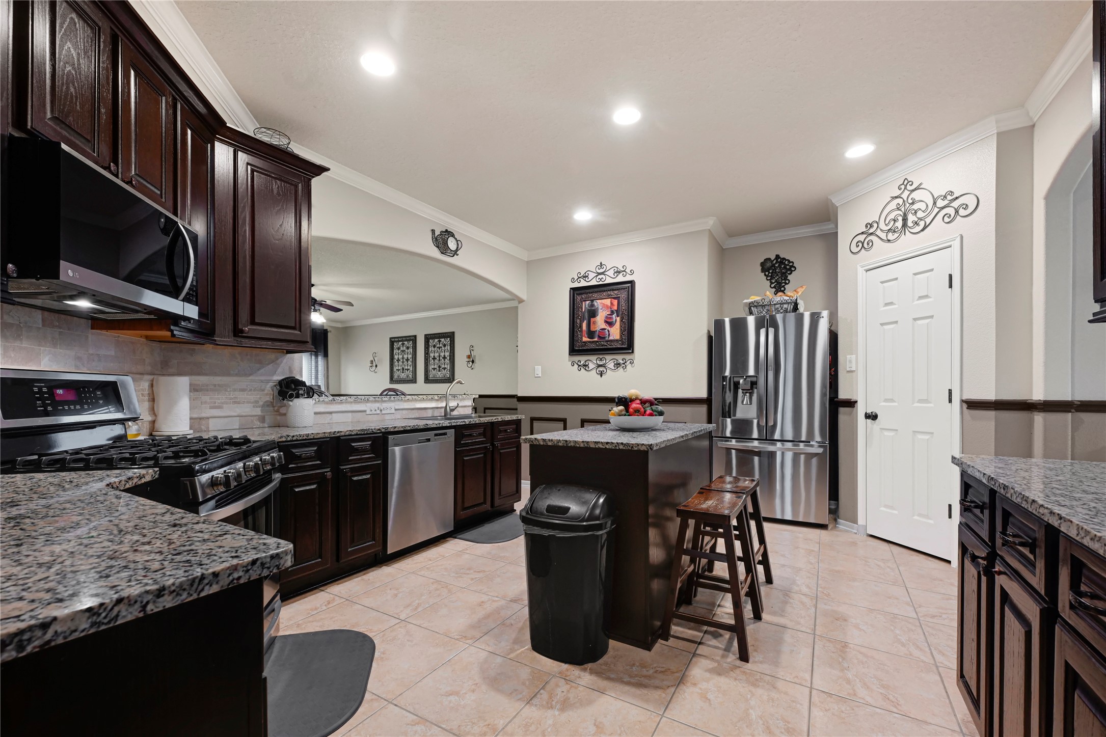 15306 Progress Ridge Way Cypress, TX 77429 - Photo 11 of 37 a kitchen with stainless steel appliances granite countertop a stove top oven a sink dishwasher a dining table and chairs with wooden floor