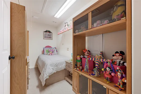 a bedroom with a bed and a flat tv screen on the dresser