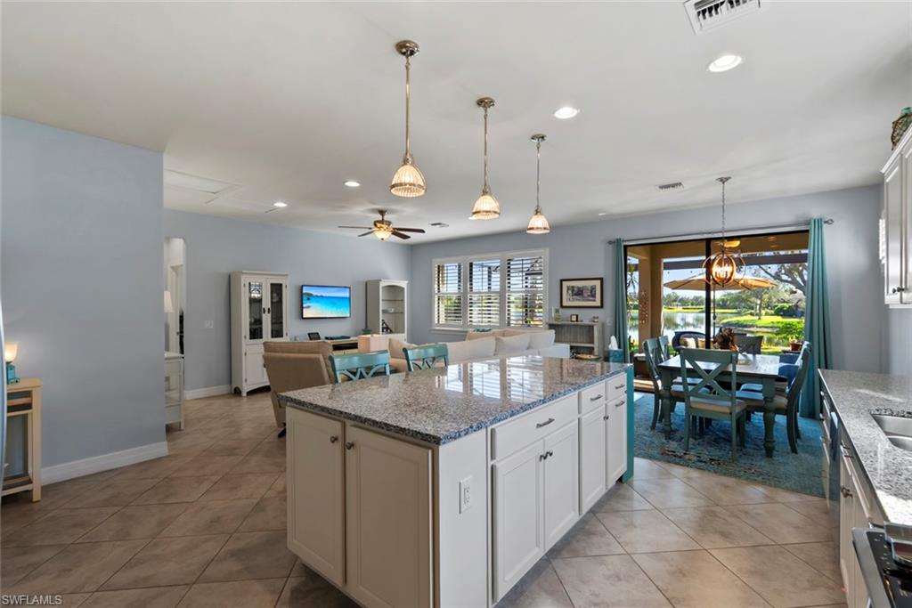 6264 Victory Drive Immokalee, FL 34142 - Photo 7 of 44 a kitchen with a counter space dining table and a chandelier