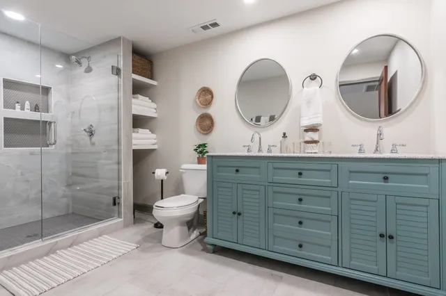 a bathroom with a double vanity sink mirror and toilet