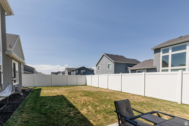 349 West 3085 South Logan, UT 84321 - Photo 28 of 37 Fenced backyard featuring a concrete patio, expansive lawn, and white vinyl privacy fencing