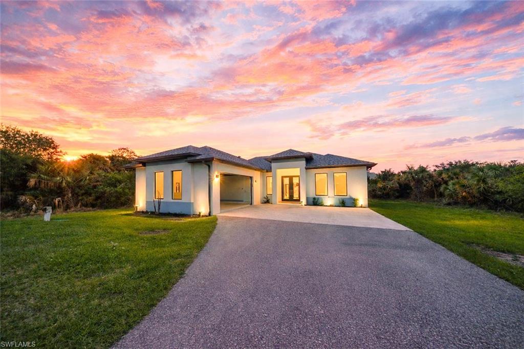 808 37th Avenue Northwest Naples, FL 34120 - Photo 1 of 27 a front view of a house with a yard and garage
