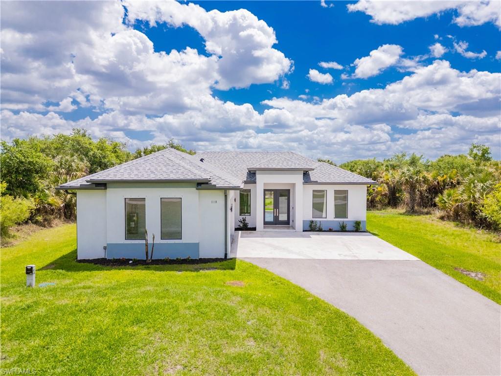 808 37th Avenue Northwest Naples, FL 34120 - Photo 3 of 27 a front view of a house with a garden