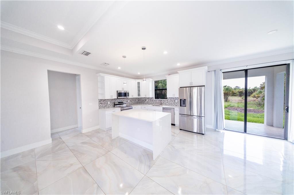 808 37th Avenue Northwest Naples, FL 34120 - Photo 7 of 27 a view of kitchen with stainless steel appliances refrigerator oven and microwave
