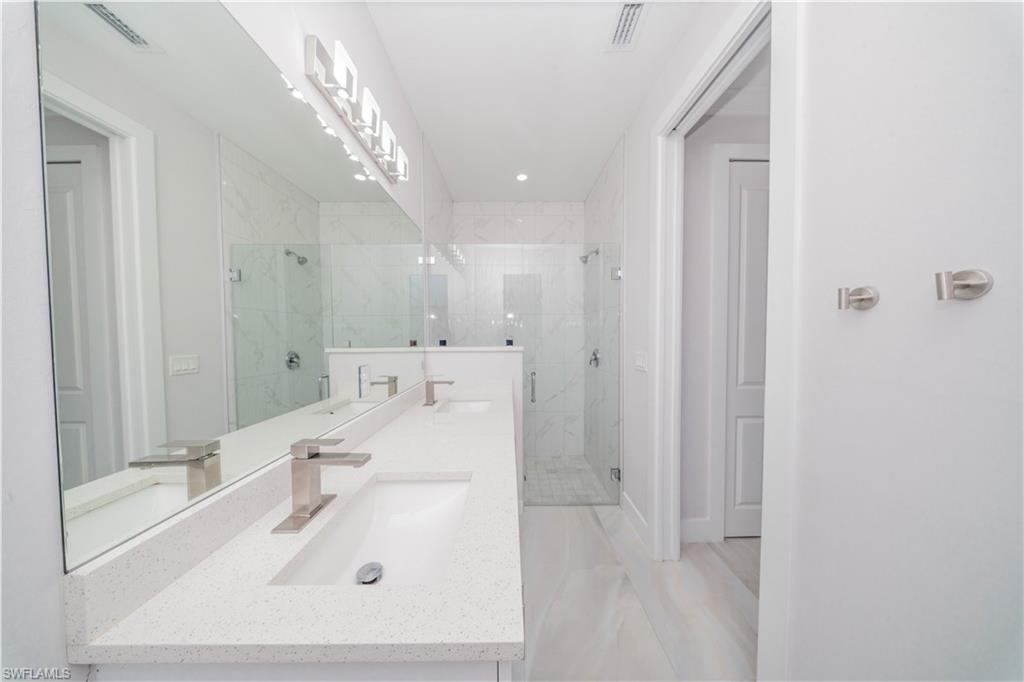 808 37th Avenue Northwest Naples, FL 34120 - Photo 10 of 27 a bathroom with a sink a shower and a mirror