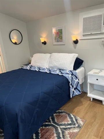 a bedroom with a bed and a painting on the wall