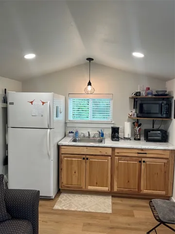 a kitchen with stainless steel appliances a sink a refrigerator and a couch