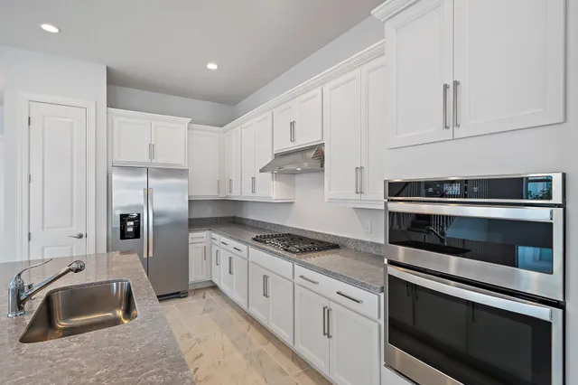 a view of a kitchen with a sink and a refrigerator