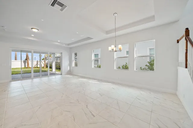 an empty room with windows and painting on the wall