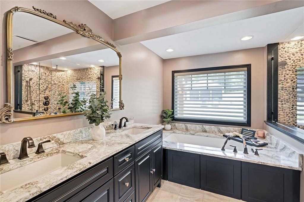 13399 Treasure Lake Road Du Bois, PA 15801 - Photo 18 of 49 a bathroom with double vanity sinks a large mirror and a bathtub