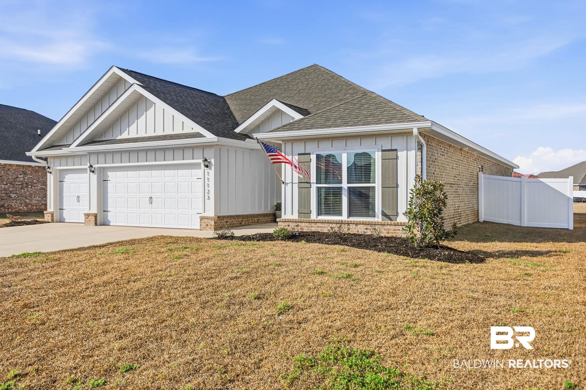 11123 Genuine Risk Circle Daphne, AL 36526 - Photo 2 of 67 Ranch-style home featuring board and batten siding, a garage, driveway, brick siding, and roof with shingles
