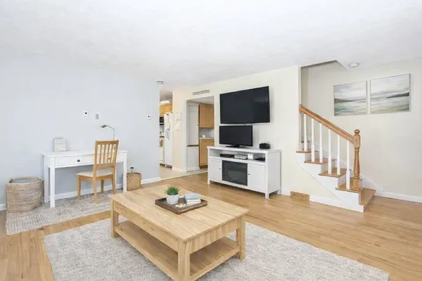 a living room with furniture a flat screen tv and a table