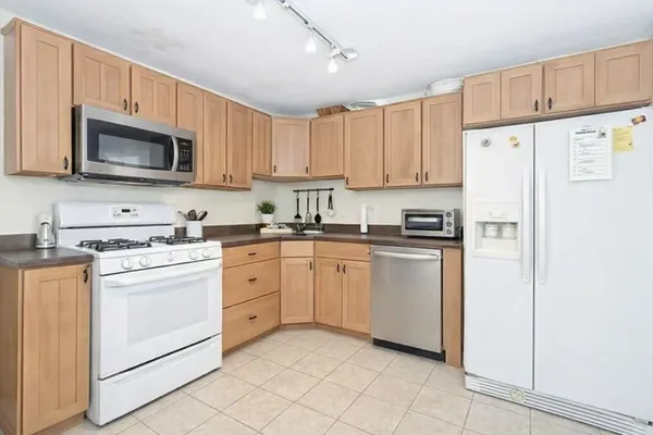 a kitchen with white cabinets and white appliances