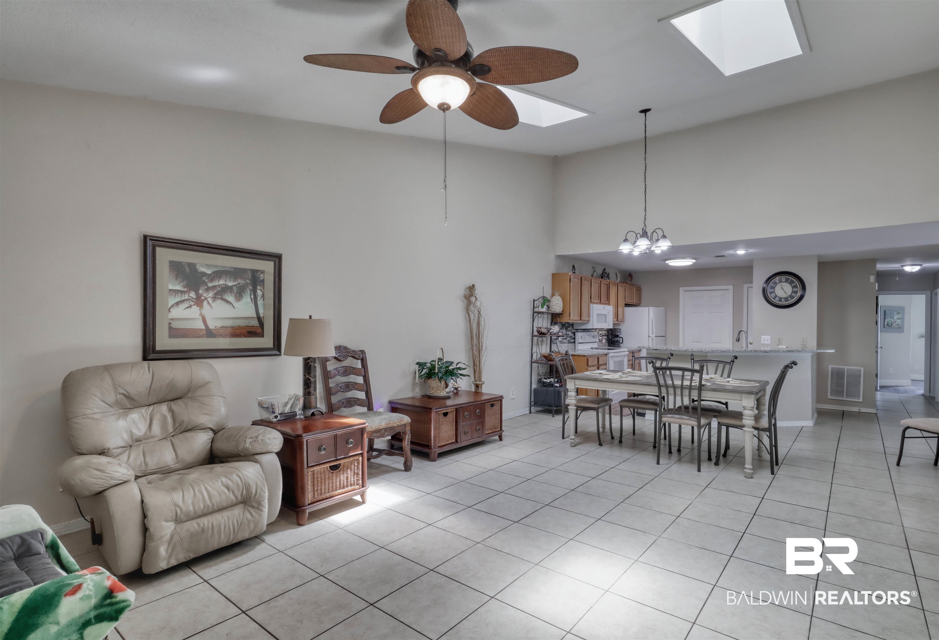 3200 Loop Road, Unit 61 Orange Beach, AL 36561 - Photo 9 of 32 Living area featuring a skylight, a chandelier, a ceiling fan, light tile patterned floors, and a high ceiling