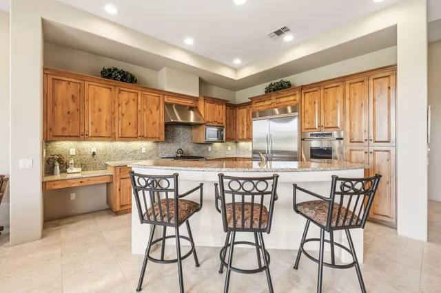 a kitchen with refrigerator and chairs