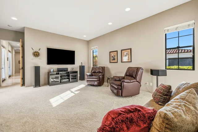 a living room with furniture a window and a flat screen tv
