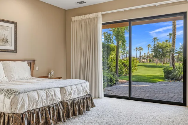 a spacious bedroom with a bed and a chandelier