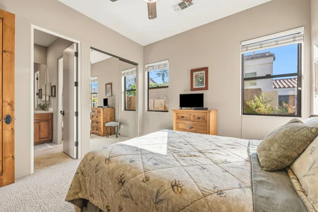 a spacious bedroom with a bed and a chandelier