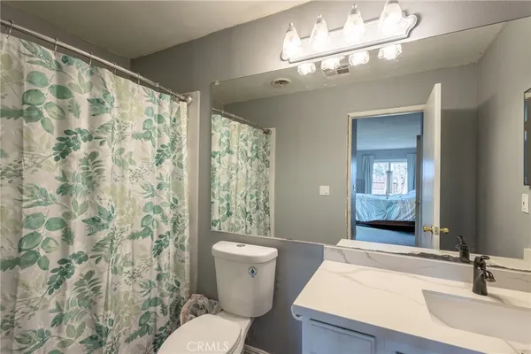 a bathroom with a sink a toilet a mirror and a shower