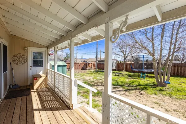 a view of a porch with wooden floor and fence