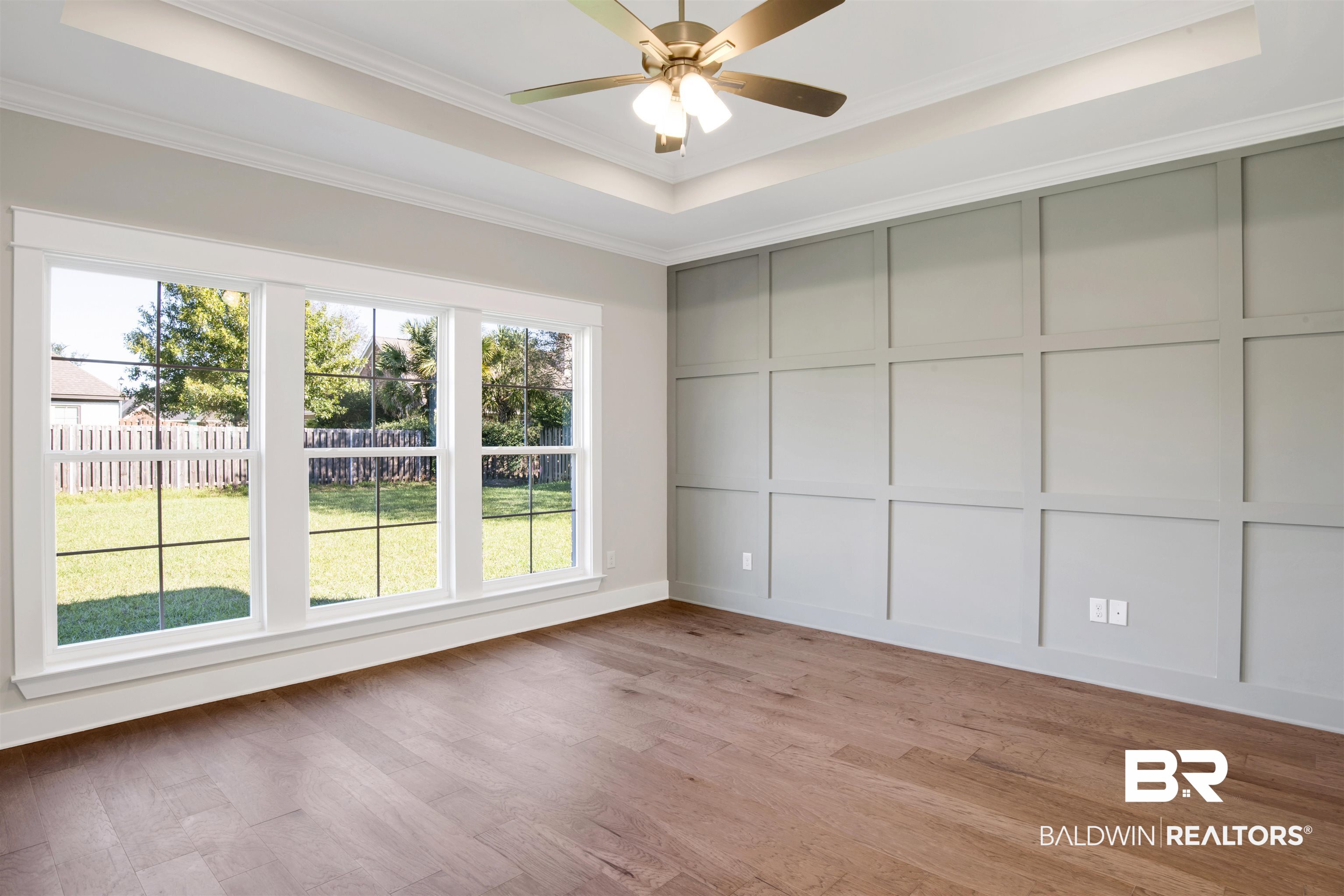 9687 Widgeon Court Daphne, AL 36526 - Photo 17 of 40 Empty room featuring hardwood / wood-style flooring, a raised ceiling, ceiling fan, and crown molding