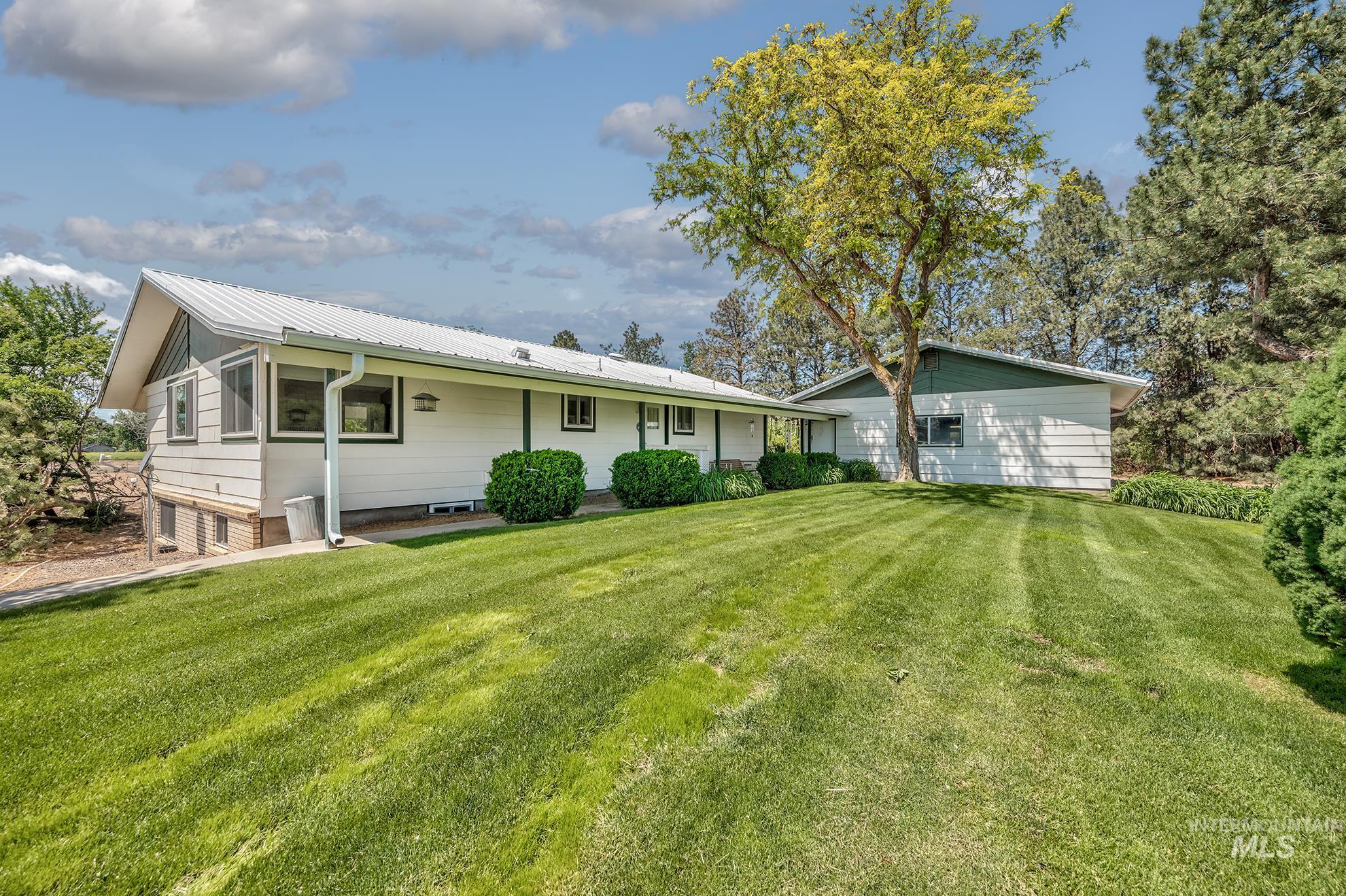748 Pringle Road Weiser, ID 83672 - Photo 36 of 47 White siding exterior with a metal roof and green trim