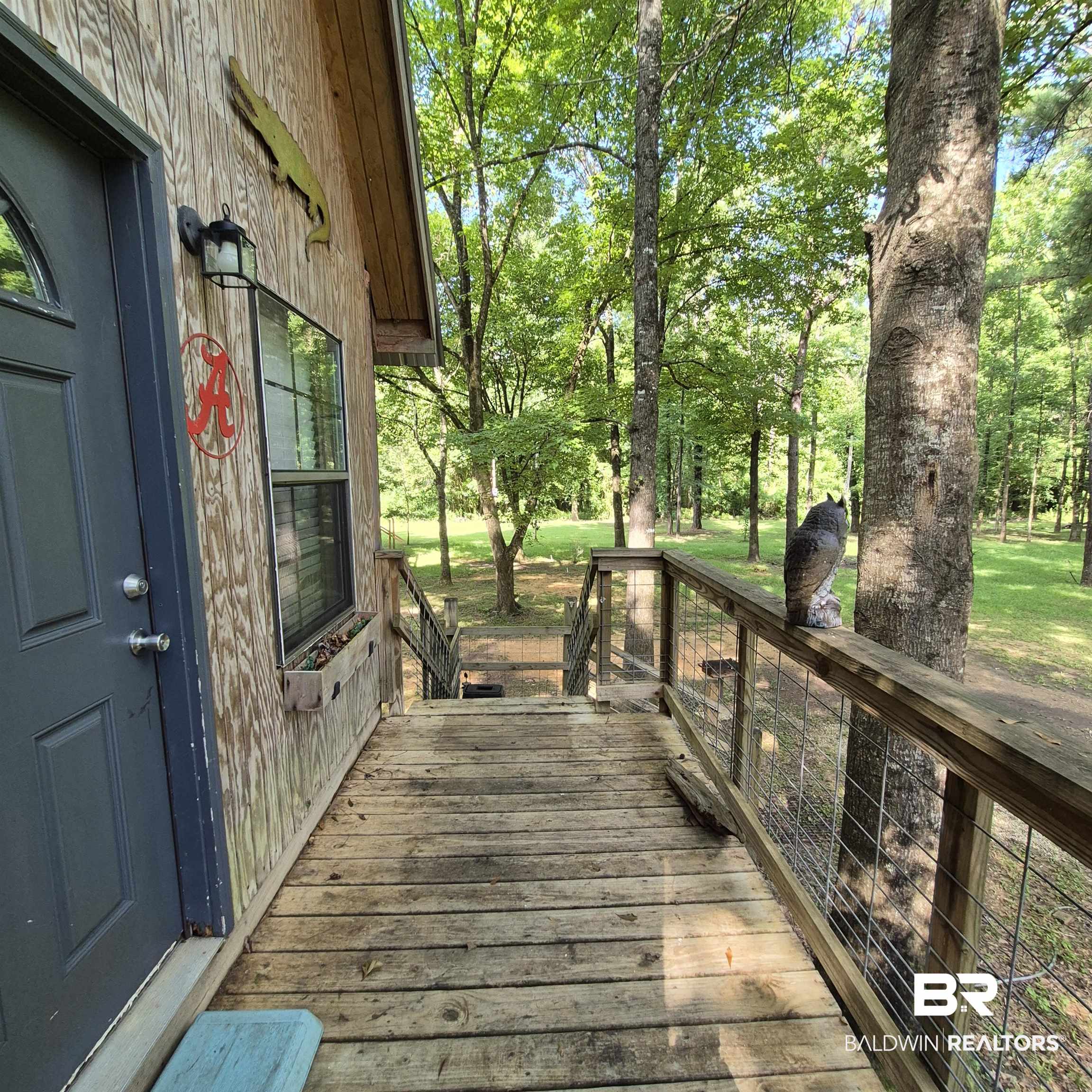 0 Eureka Landing Road Uriah, AL 36480 - Photo 18 of 27 Wood-sided exterior featuring a built-in window box and a dark entry door with an arched glass insert