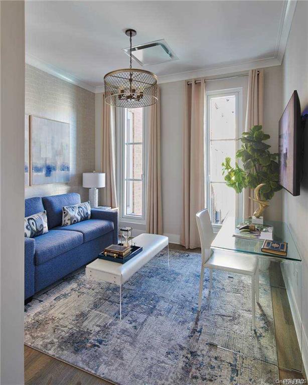 100 Garvies Point Road, Unit 1202 Glen Cove, NY 11542 - Photo 3 of 14 Living area featuring wood finished floors, crown molding, and a chandelier