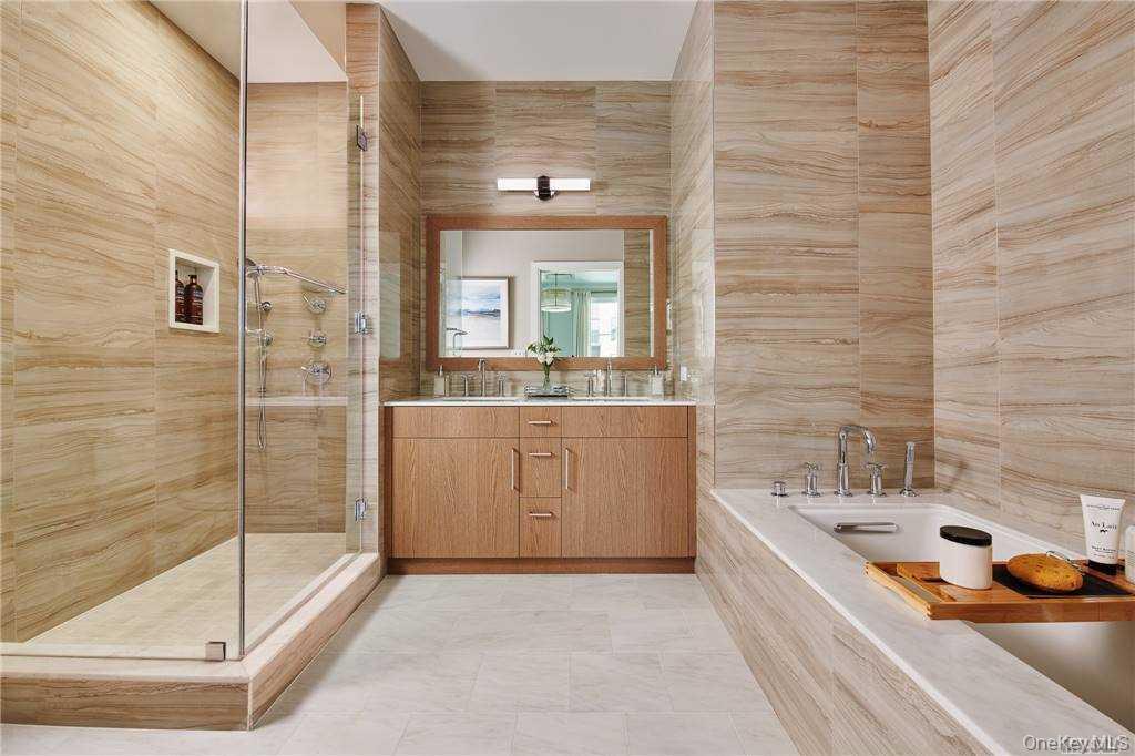 100 Garvies Point Road, Unit 1202 Glen Cove, NY 11542 - Photo 5 of 14 Bathroom featuring tile walls, a stall shower, vanity, a bath, and light tile patterned flooring