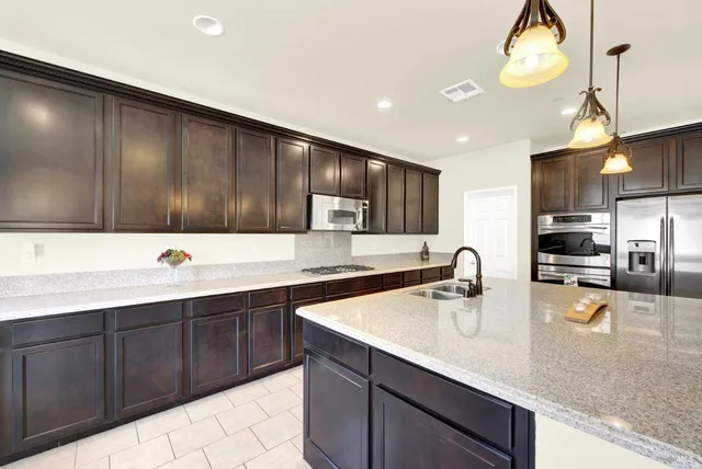 a large kitchen with kitchen island a sink counter space and a view of living room