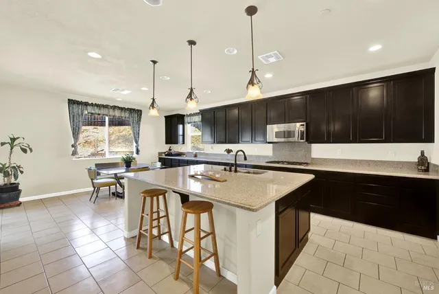 a kitchen with a sink a counter top space appliances and cabinets