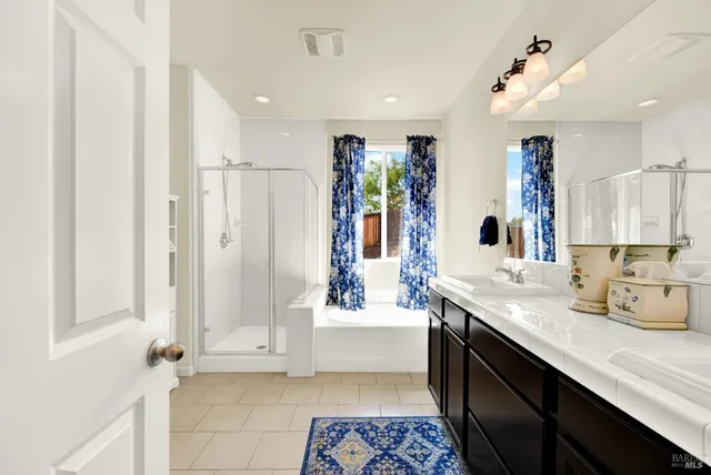 a bathroom with a double vanity sink a mirror and shower