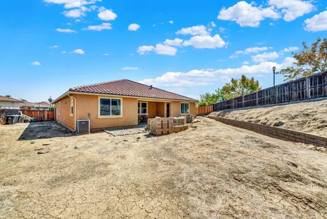a backyard of a house with wooden fence