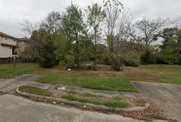 a backyard of apartments with large trees